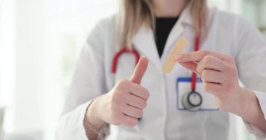 Doktor bir yama tutuyor ve hastanede onaylıyor. Yaralar ve nasırlar için alçı önerisi
