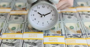 On bin dolarlık banknotların üzerindeki çalar saat. Para kazanma zamanı.
