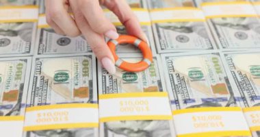 Bir insan 100 dolarlık banknotların üzerine can yeleği koyar. Para mevduatlarının mali sigortası
