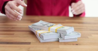 Kadın yönetici masadaki yığınla Amerikan dolarını alıyor. Parasal rüşvet ve yasadışı mali gelir almak.