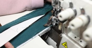 Turkuaz kumaş üzerinde çalışan dikiş makinesinin kapanışı. Terzilik