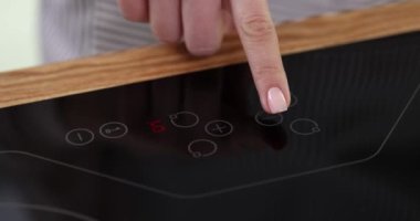 Kadın düdüklü tencerede eksi düğmeye basıyor. Elektrikli dokunmatik fırın konsepti için kullanım kılavuzu