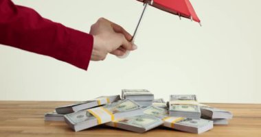 Sigorta acentesi bir şemsiye altında tomarla para. Para mevduatlarının korunması, güvenliği ve sigortası