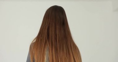 Üzgün, genç bir kadın beyaz arka planda dönüp gidiyor. Ayrılma ve ayrılma duyguları