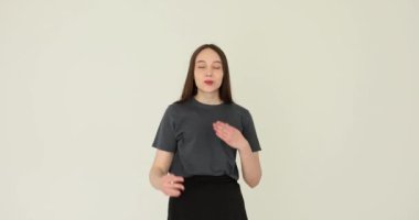 Beyaz bir arka planda hava öpücüğü yollayan genç bir kadın. Kız öğrenci sevgi ve şefkat mesajı gönderiyor.