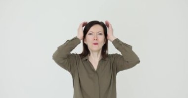 Elleriyle başını tutup çığlık atan bir kadın. Korku, stres ve şok hissi.