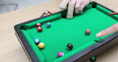 Oyuncu top ve ıstakayla mini bilardo oynuyor. Evde bilardo oynuyorum.