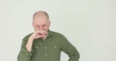 Adam burnunu karıştırıyor ve burnunu beyaz arka plana sürtüyor. Burnumu ve gözümü ovmaktan yoruldum. Yorgunum ve başım ağrıyor. Stres ve hayal kırıklığı kavramı