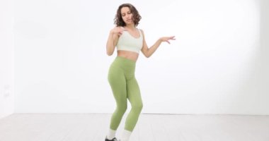 Deri giyen kadın beyaz arka planda dans ediyor. Dans okulları ve online dersler