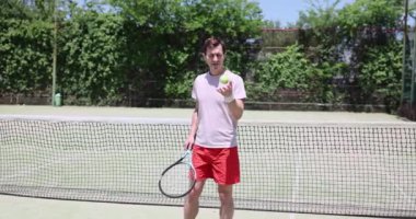 Adam güneşli bir günde kortta tenis topuyla hokkabazlık yapıyor. Tenis ve sağlık oynamak