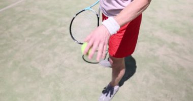 Tenisçi ayağının yanında zıplayan top. Tenisçi adam tenis oynuyor