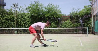 Tenis oyuncusu güneşli bir günde topa uzanır. Teniste servis topu.