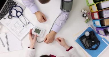 Doktor, hastaların kan basıncını ölçer. Kalp atış hızı izleme, kardiyoterapist yardımı ve konsültasyon