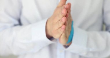 Closeup of man hand in a white shirt, clenching a fist and nervously worrying. Folded male hands and nervous anxiety