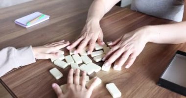 İnsanlar tahta bir masada domino oynuyorlar. Anne kız domino oynuyorlar.