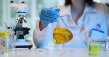 Kimyager test tüpünü kimyasal sıvı ve temizlik için yakıt ile tutuyor. Laboratuvarda petrolün kimyasal deneyleri üzerine çalışıyorum..
