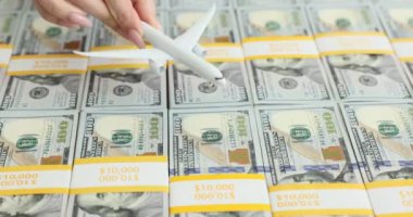 Yığınla Amerikan doları ve bir uçak. Yükselen hava yolculuğu fiyatları