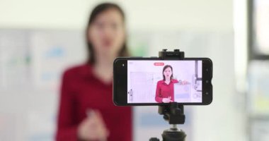 İş blogcusu ve işletme okulu pazarlamacısı kamera önünde video kaydediyor. Onaylanmış öneriler, analitik istatistikler ve uzak video konferansları