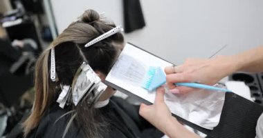 Güzellik salonunda folyodaki saçı renklendirme işlemi. Güzellik salonunda profesyonel usta tarafından renklendirme işlemi