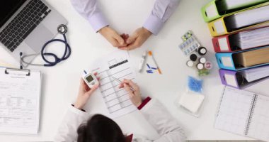 Hastanedeki hastadan kan örneği alan bir doktor. Kan şekeri kontrolü