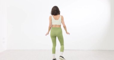 Beyaz arka planda dans eden genç bir kadın. Stüdyoda dans eğitimi.