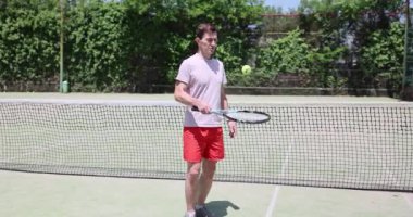 Tenisçi raket üzerinde top tekniği uyguluyor. Aktif hobi ve sağlıklı yaşam tarzı