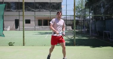 Adam kortta tenis oynuyor ve kendini kötü hissediyor. Spor yorgunluğu ve yorgunluğu.