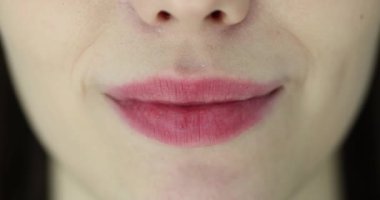 Yumuşak pembe ruj ve güzel bir kadın gülüşü. Kadın yüzünün doğal güzelliği.