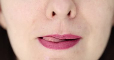 Dudaklarını yumuşak bir ruj ve dille süsle. Kırmızı dudakları yalayan ve seksi bir kadın.