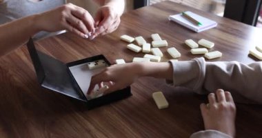 Oyuncular domino bloklarını bir kutuya koyarlar. Aile bir domino tahtası oyununu bitirir