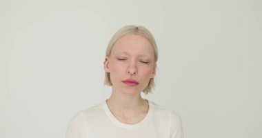 Genç kız minimalist piercing modasını sergiliyor. Güzel bir kadın düşünceli bir şekilde kameraya bakar.