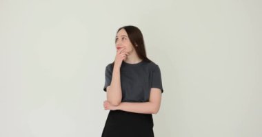 Düşünceli genç bir kadın beyaz arka plan üzerinde kafa yoruyor. Meslek seçimi ya da hayatın ve konseptin diğer alanları. Karar verirken düşünceli genç bayan.