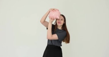 Bayan öğrenci domuz kumbarasını sallıyor ve tasarruf kavramını test ediyor. Finansal tasarruf ve para krizi