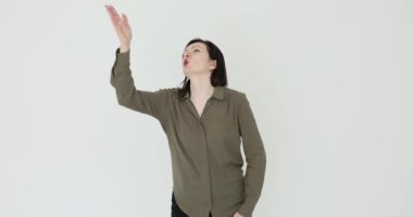 Beyaz arka plana öpücük kondurarak sevgi ve minnettarlığını ifade eden bir kadın. Aşk duygusunun jesti minnettarlık