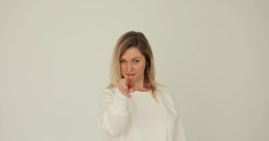 Güzel bir kadın özgüvenle el kol hareketi yapıyor. Beyaz arka planda gözlerimin içine bak. Seni izleyen ve göz teması kuran duygular
