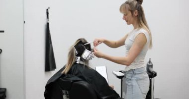 Kuaförde saç şekillendirme seansı. Röfle ve boyama kullanılarak. Güzellik salonunda saç boyama tedavisi gören bir müşteri.