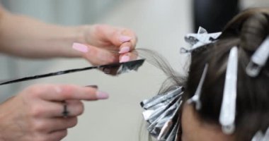 Güzellik salonuna saç boyası sürme işlemi. Kadın işçiler her ipliğin eşit dağıtılmasını ve renklendirmeye hazırlanmasını sağlarlar.