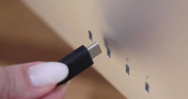 Teknoloji demosu sırasında USB-C kablosunu şık bir cihaza bağlamak. USB tip C konnektörü, elinde siyah kabloyla monitöre bağlanıyor.