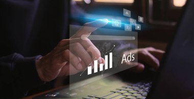 Çevrimiçi pazarlama ve web sitesi reklam konsepti. Genç adam dijital kanallar aracılığıyla ürün veya hizmetlerin tanıtımı için dijital pazarlama stratejisi analizine sahip dizüstü bilgisayar kullanıyor.