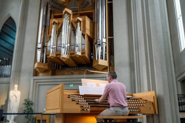 Iceland, Reykjavik - 2023: Professional Organist plays music on church organ inside of Hallgrimskirkja Reykjavik, Iceland. clipart