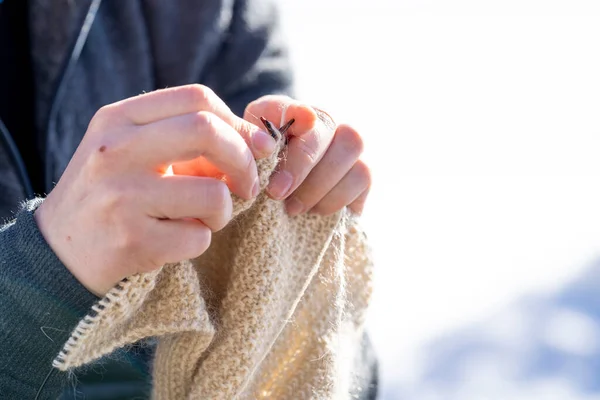 用毛线做针织女用手织衣服是艰苦劳动的结果 年轻女子在外面用羊毛织线做衣服 — 图库照片