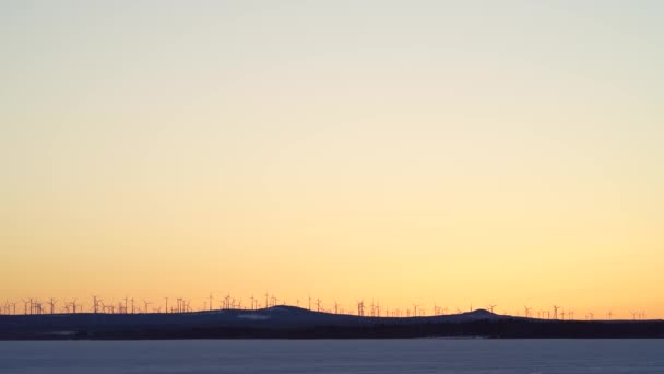 マーク コーデン ウィンドミル公園は スウェーデン北部ペイクの郊外の丘で日没時に緑の電気を回転させる動きで風力タービンと距離を置いています — ストック動画