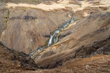 Djupagil kanyonu ve Reykjadalur Vadisi 'ndeki Djupagilsfoss şelalesi Güney İzlanda' da sıcak bir nehirde yıkanmanın mümkün olduğu yere yakın..