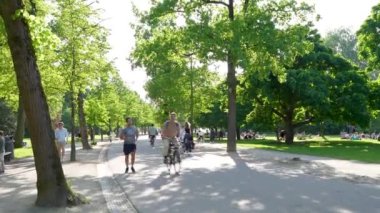 Amsterdam, Hollanda - Mayıs 2024: Her yaştan insan parkların keyfini çıkarırken kendinizi Vondelpark 'ın canlı atmosferine daldırın.