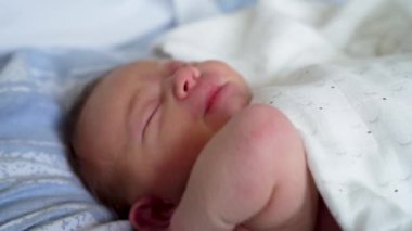 Yeni doğmuş bir bebek, anne ve babasına bakıyor. Hastane ortamında açlık ve ilgi istiyor. Görüntü, bebeğin doğal açlık sinyallerini ve ebeveynin sağladığı bakımı yakalar..