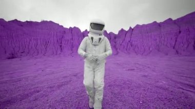 Neşeli bir astronot mor bir gezegende dans ediyor. Astronot uzak bir gezegene yaptığı yolculuktan çok memnun ve neşeyle dans ediyor..
