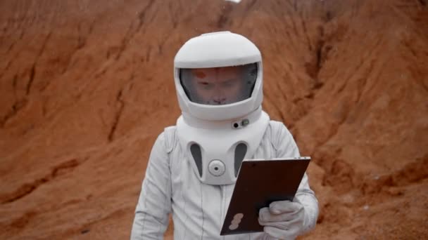 Астронавт Специальном Костюме Шлеме Ходит Табличкой Поверхности Марса Исследование Запись — стоковое видео