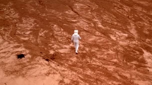 一个无人驾驶宇航员在这个星球的陨石坑周围散步时开枪射击 身穿白色防护服 头戴头盔的宇航员探索陨石坑的表面 — 图库视频影像