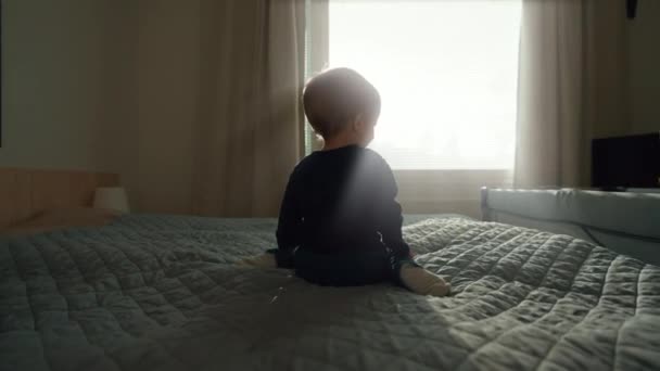 Мальчик Улыбается Поворачиваясь Посмотреть Камеру Сидя Кровати Яркого Окна Симпатичный — стоковое видео