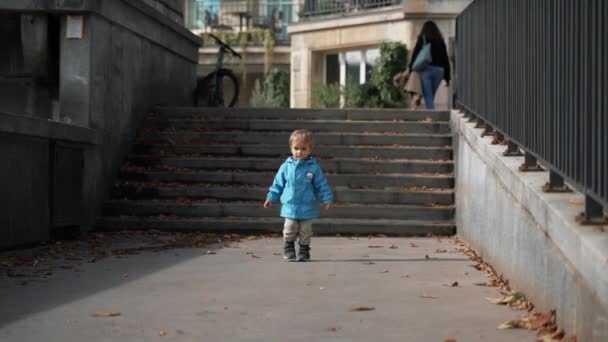 Aranyos Szőke Kisbaba Visszasétál Lépcsőhöz Családi Sétányon Városban Kék Kabátos — Stock videók